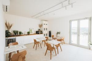 a restaurant with white tables and chairs and windows at Ritrovare Country House in Citta' Sant'Angelo