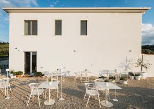 a group of tables and chairs in front of a white building at Ritrovare Country House in Citta' Sant'Angelo