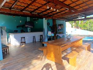 a dining room with a wooden table and a counter at Linda Chácara Próxima a Monte Verde in Camanducaia