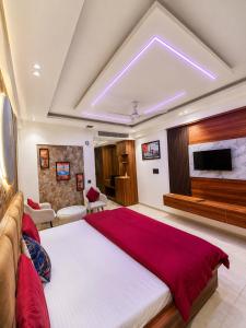 a bedroom with a large bed and a flat screen tv at Velvet stay in Lucknow