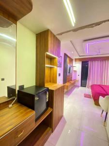 a living room with a tv on a wooden counter at Velvet stay in Lucknow +9 photos
