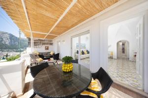 a living room with a table and chairs at Villa La Panoramica Sea View in Capri +14 photos