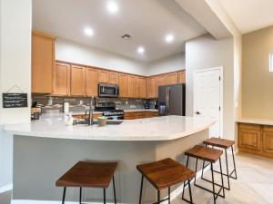 a kitchen with wooden cabinets and a counter with stools at Anthem Allure in Phoenix +28 photos