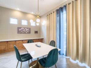 a dining room with a white table and green chairs at Anthem Allure in Phoenix