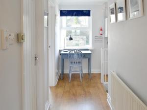 a desk in a hallway with a chair and a window at Buzzards - 8235 in Bridport