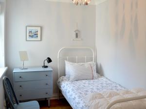 a white bedroom with a bed and a dresser at Buzzards - 8235 in Bridport +6 photos