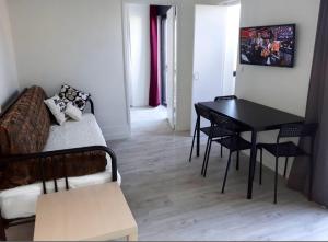 a living room with a couch and a dining room table at Au Trèfle Dort in Châtel-Guyon