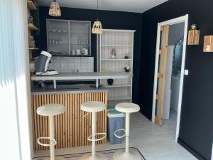 a kitchen with two stools and a counter at Les Terasses d Eole in Assigny