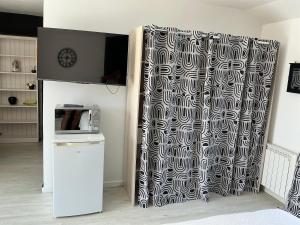 a kitchen with a black and white shower curtain at Les Terasses d Eole in Assigny