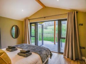 a bedroom with a bed and a large window at Poplar Lodge - Uk50625 in Welshpool
