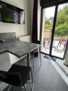 a dining room with a table and chairs and a window at Au Trèfle Dort in Châtel-Guyon