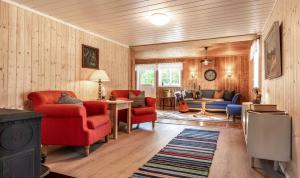 a living room with red chairs and a tv at Villa Fregn in Ljørdalen