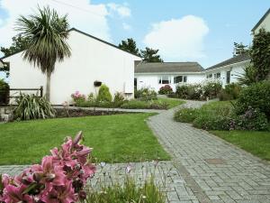 a house with a garden with pink flowers at Fistral in Saint Merryn