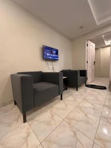 a living room with a couch and a tv on the wall at 1 BHk, Bed Hall Kitchnett in Lahore