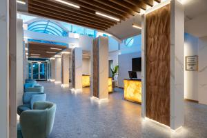 an office lobby with blue chairs and a ceiling at Effect Grand Victoria Hotel - Ultra All Inclusive in Sunny Beach