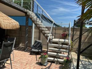 a set of stairs with two chairs and flowers at Les Terasses d Eole in Assigny