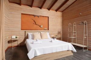 a bedroom with a white bed in a wooden wall at Hilltop Chalet 2 in Hanioti