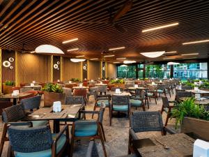 a restaurant with wooden tables and chairs and tables and chairs at Effect Grand Victoria Hotel - Ultra All Inclusive in Sunny Beach