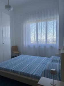 a bedroom with a blue bed with a window at La Terrazza d'Abruzzo in Guardiagrele
