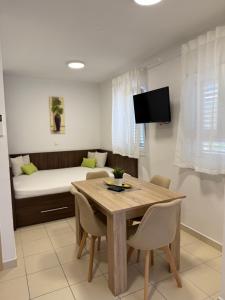 a living room with a table and a bed at Apartmani Pernjak in Mandre