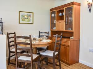 a dining room with a wooden table and chairs at Cherry Barn in Dufton