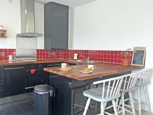 a kitchen with a wooden counter with chairs and a sink at 6 Pentire Mews in Newquay