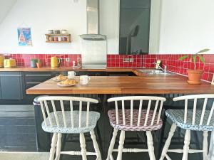 a kitchen with a counter with two chairs and a sink at 6 Pentire Mews in Newquay +8 photos