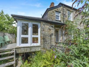 ein Steinhäuschen mit Veranda und Terrasse in der Unterkunft Primula House in Sticklepath
