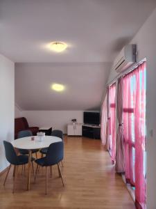 a dining room with a table and chairs in a room at Villa Magnolija in Mlini
