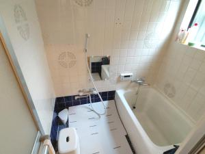 a bathroom with a tub and a toilet and a sink at OZigaoka Guest House in Otsu +27 photos
