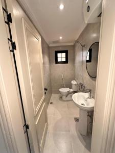 a bathroom with a sink and a toilet and a door at عالم الضيافة in Al ‘Azīzīyah