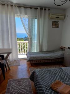 a bedroom with two beds and a large window at Tina Rooms in Ulcinj