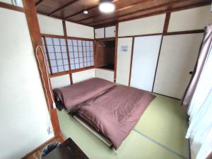 a small room with a bed in the corner at OZigaoka Guest House in Otsu