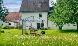 a garden in front of a white house at Landhaus Laux in Schmitt