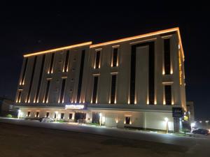 a large white building with lights on it at night at iqama mumayyaza الإقامة المميزة للشقق المخدومة - إقتصادي in Tabuk