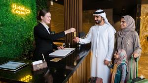 a man handing a bottle of wine to a woman at Aparthotel costa in Makhinjauri