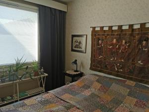 a bedroom with a bed and a window at Maribo Street Home in Kaskö