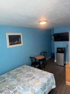 a bedroom with blue walls and a bed and a table at Surfcomber Motel in Wildwood