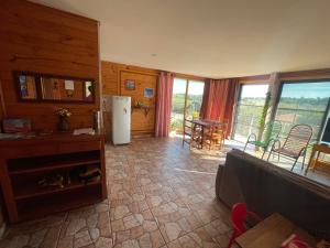 a living room with a refrigerator and a table and chairs at Swiss Chalets - Thermas Water Park in Águas de São Pedro