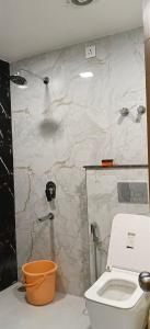 a bathroom with a toilet and a marble wall at Hotel rajveer in Jhānsi