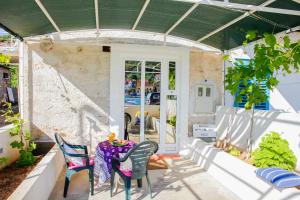 a patio with a table and chairs in a house at Apartment Mihovil 308 in Tisno