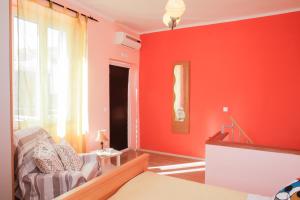 a living room with red walls and a couch at Apartment Mihovil 308 in Tisno +6 photos