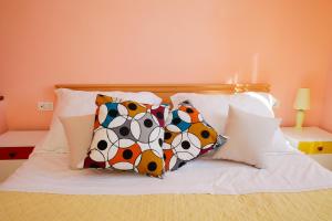 a bed with four pillows on top of it at Apartment Mihovil 308 in Tisno