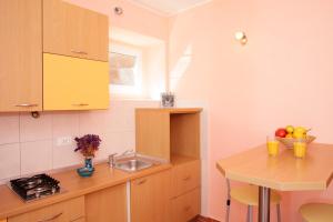 a kitchen with a sink and a table with fruit on it at Apartment Mihovil 308 in Tisno