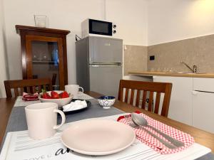 a kitchen with a table with plates and utensils at Fuga nel borgo in Avigliana