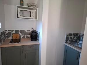 eine kleine Küche mit einer Mikrowelle an der Wand in der Unterkunft Studio in Levens