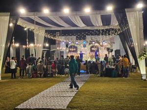 a group of people standing under a tent at a party at Vasant Corbett Resort By Mannat in Rāmnagar +65 photos