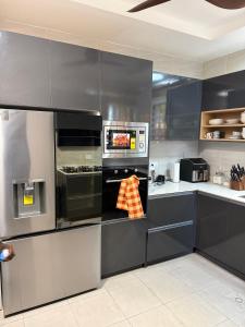 a kitchen with gray cabinets and an oven at Asibbey Lodge in Maijaw