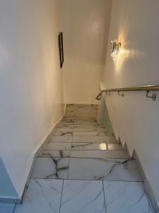 a staircase with white walls and tile floors at Asibbey Lodge in Maijaw +32 photos