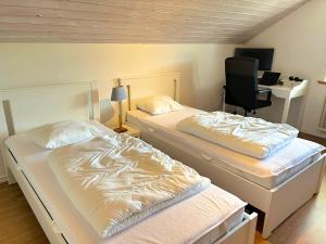 two beds in a room with a desk and a chair at Villa Dångebo in Tingsryd